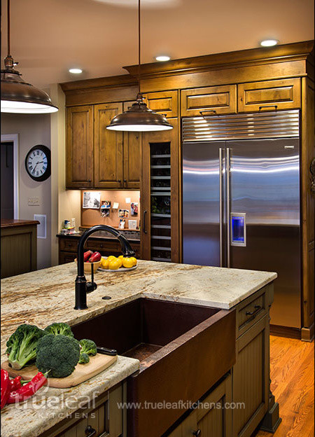 Eat-in kitchen - country medium tone wood floor eat-in kitchen idea in New York with a farmhouse sink, recessed-panel cabinets, medium tone wood cabinets, granite countertops, beige backsplash, ceramic backsplash, stainless steel appliances and an island