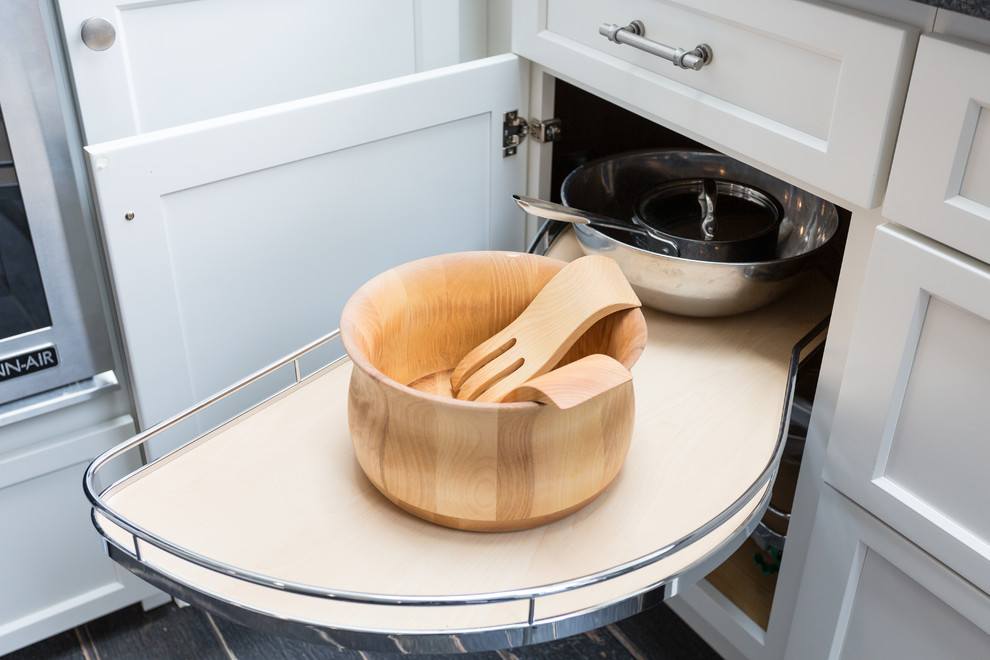 Idée de décoration pour une grande cuisine tradition en L fermée avec un évier encastré, un placard à porte plane, des portes de placard blanches, un plan de travail en granite, une crédence blanche, une crédence en céramique, un électroménager en acier inoxydable, un sol en carrelage de porcelaine et îlot.