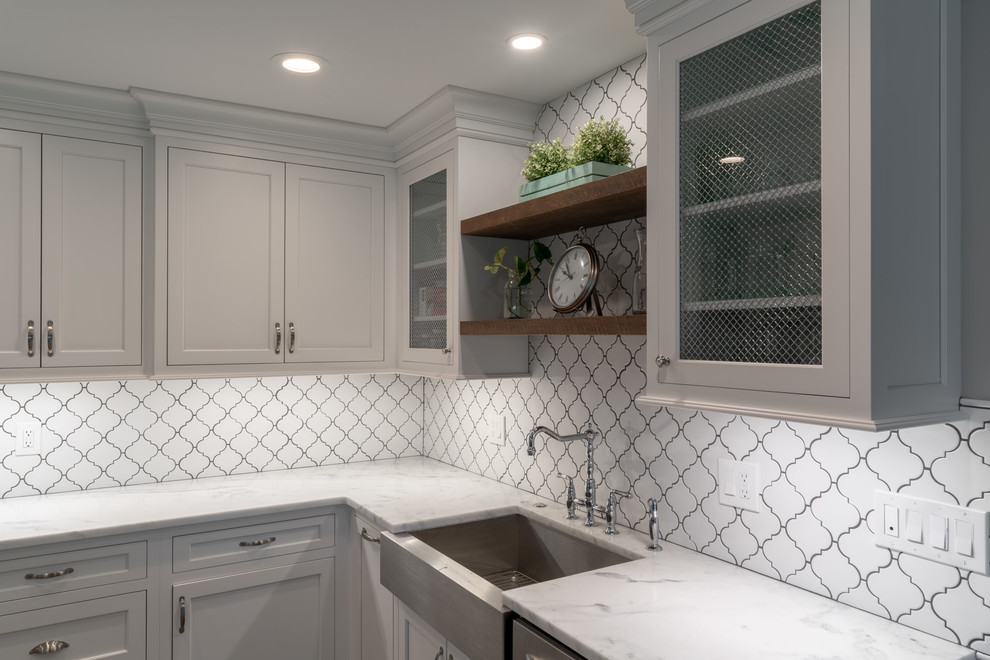Modern inredning av ett mycket stort vit vitt kök, med en rustik diskho, skåp i shakerstil, vita skåp, marmorbänkskiva, vitt stänkskydd, stänkskydd i porslinskakel, rostfria vitvaror, mellanmörkt trägolv, en köksö och grått golv