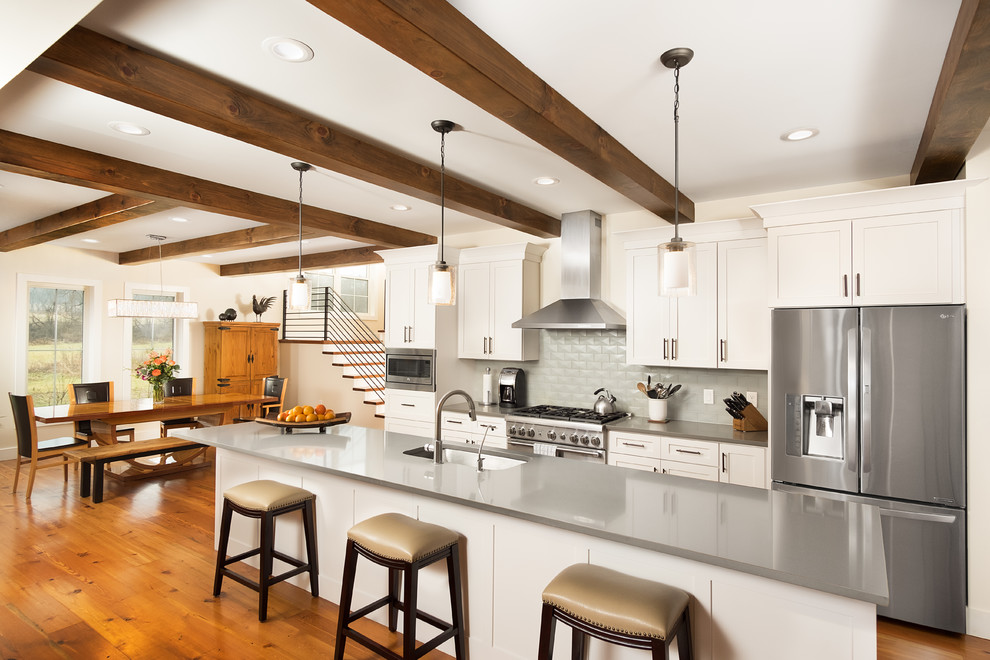 Inspiration for a large cottage galley medium tone wood floor and brown floor eat-in kitchen remodel in Other with an undermount sink, white cabinets, quartzite countertops, blue backsplash, glass tile backsplash, stainless steel appliances, an island, gray countertops and shaker cabinets