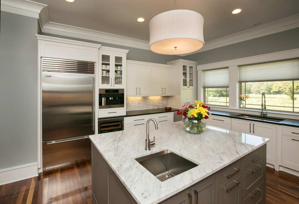 Example of a mid-sized minimalist u-shaped medium tone wood floor eat-in kitchen design in Dallas with an undermount sink, shaker cabinets, white cabinets, marble countertops, gray backsplash, stone tile backsplash and stainless steel appliances