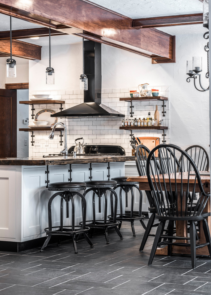 Large country u-shaped slate floor and black floor eat-in kitchen photo in Other with a farmhouse sink, recessed-panel cabinets, white cabinets, quartz countertops, white backsplash, ceramic backsplash, black appliances, an island and black countertops