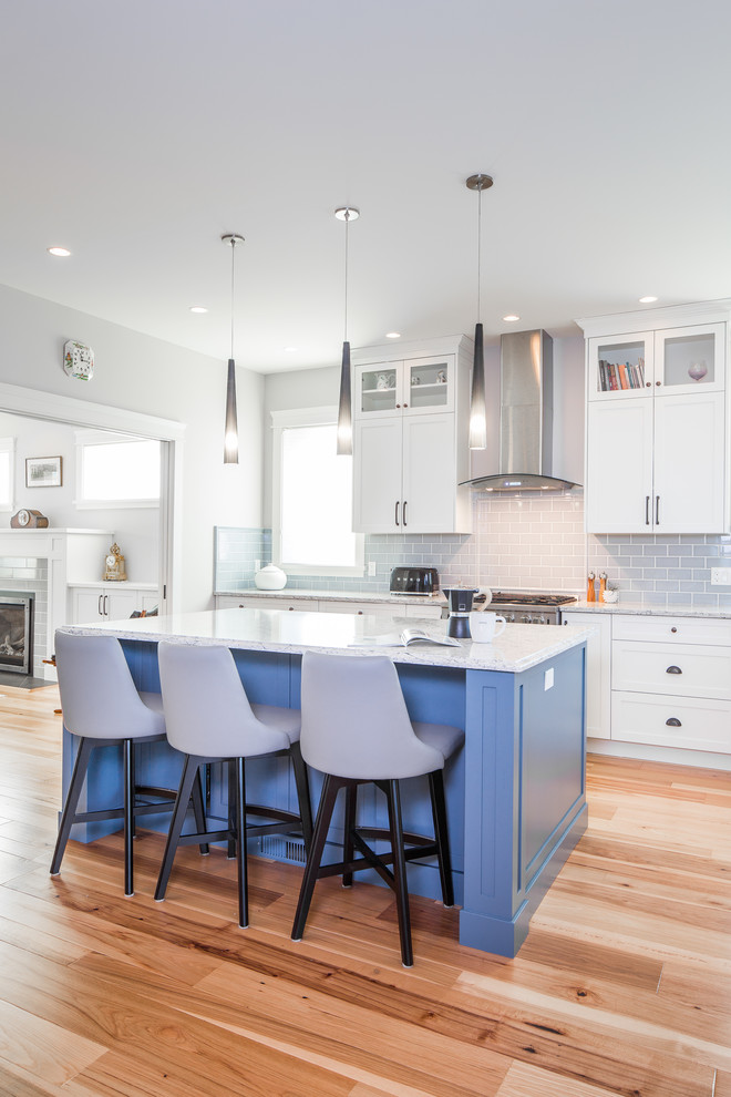 Inspiration for a large farmhouse l-shaped medium tone wood floor and brown floor eat-in kitchen remodel in Vancouver with a farmhouse sink, shaker cabinets, blue cabinets, quartz countertops, gray backsplash, ceramic backsplash, stainless steel appliances, an island and white countertops
