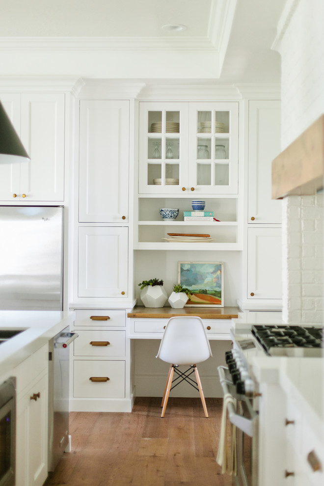 Example of a cottage medium tone wood floor kitchen design in Salt Lake City with white cabinets, glass-front cabinets and stainless steel appliances