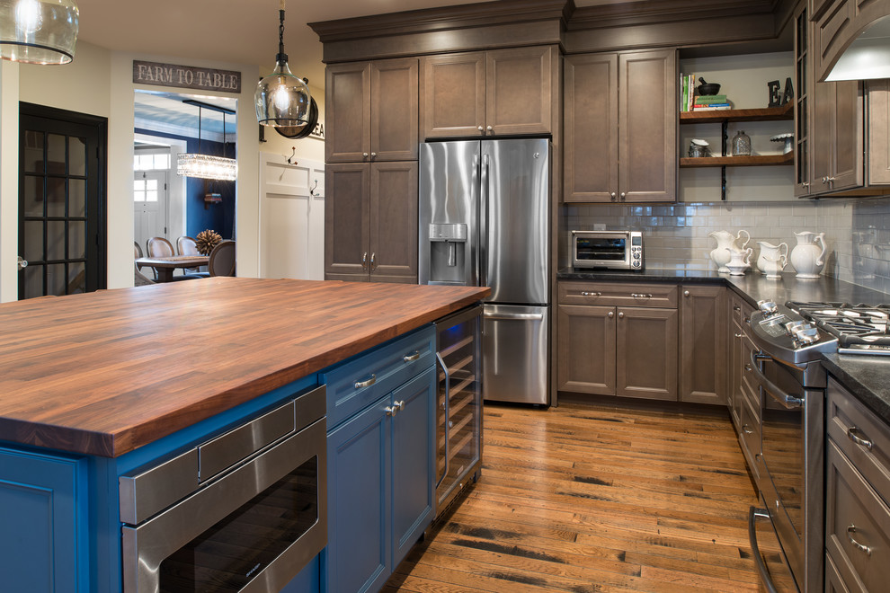 Inspiration for a mid-sized timeless u-shaped medium tone wood floor and brown floor eat-in kitchen remodel in DC Metro with an undermount sink, recessed-panel cabinets, gray cabinets, granite countertops, gray backsplash, stone tile backsplash, stainless steel appliances and an island