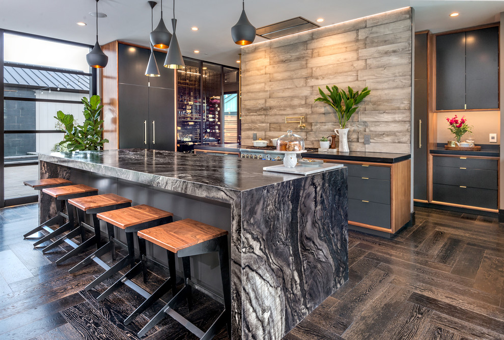 Bild på ett stort funkis kök, med en undermonterad diskho, släta luckor, grå skåp, marmorbänkskiva, brunt stänkskydd, stänkskydd i trä, rostfria vitvaror och en köksö