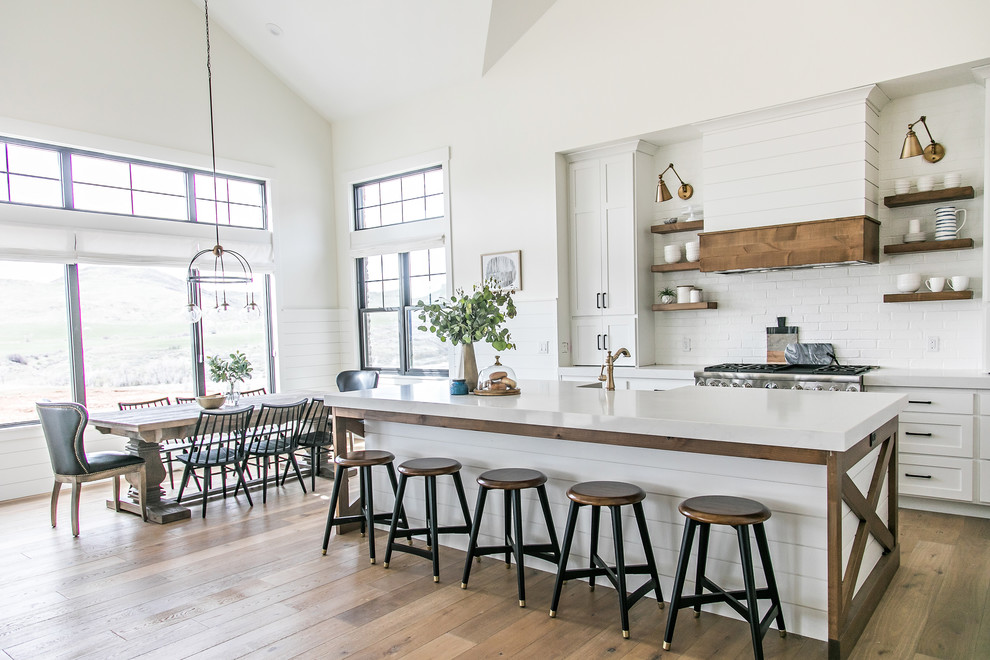 Inspiration for a country light wood floor eat-in kitchen remodel in Salt Lake City with open cabinets, white backsplash, stainless steel appliances and an island