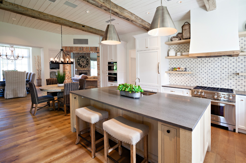 Inspiration för lantliga grått kök med öppen planlösning, med en undermonterad diskho, luckor med infälld panel, vita skåp, flerfärgad stänkskydd, rostfria vitvaror, mellanmörkt trägolv och en köksö