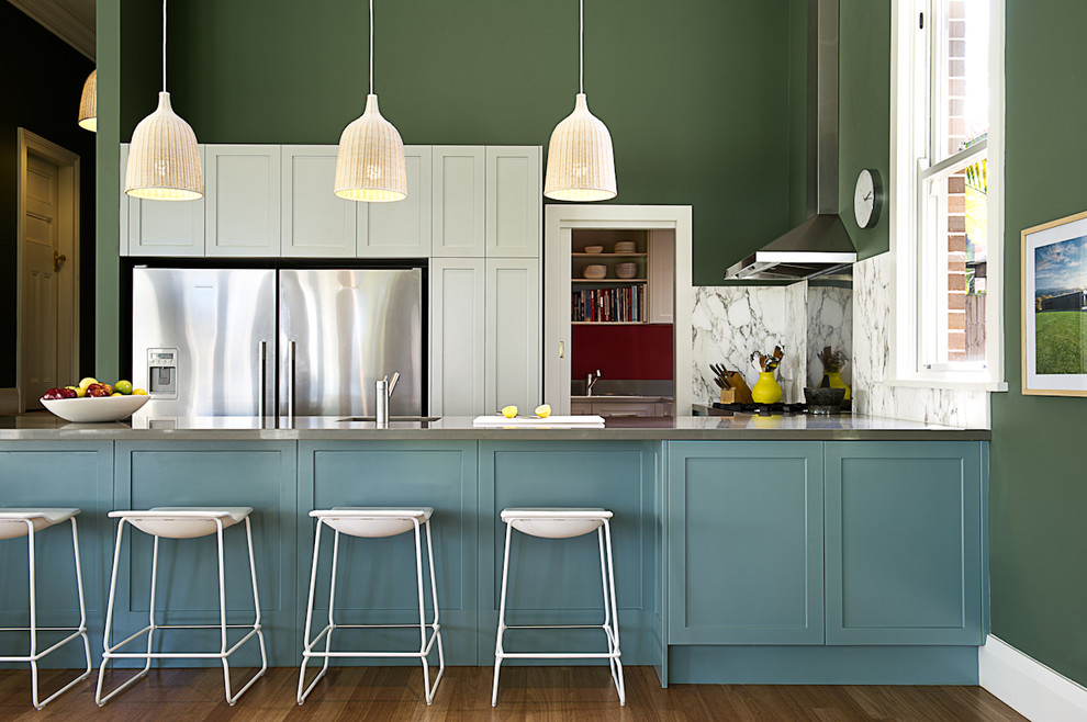 Example of a transitional u-shaped dark wood floor open concept kitchen design in Sydney with shaker cabinets, white cabinets, white backsplash, stone slab backsplash, stainless steel appliances and a peninsula