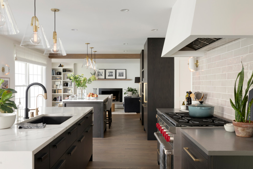 Inspiration for a transitional medium tone wood floor and brown floor kitchen remodel in Minneapolis with a single-bowl sink, flat-panel cabinets, dark wood cabinets, quartz countertops, ceramic backsplash, paneled appliances and two islands