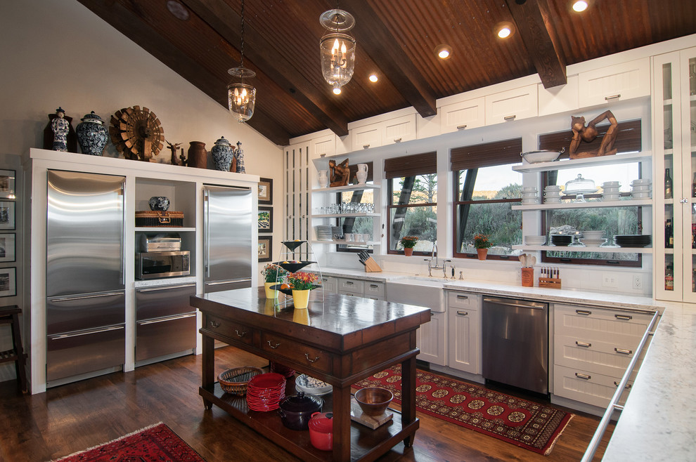 Rustic kitchen in Salt Lake City with a belfast sink, open cabinets, white cabinets, stainless steel appliances, an island, wood worktops and dark hardwood flooring.