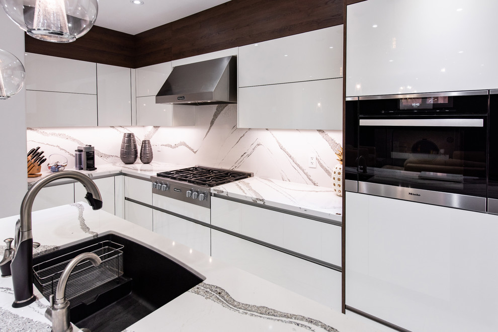 Mittelgroße Moderne Küche in L-Form mit flächenbündigen Schrankfronten, weißen Schränken, Küchenrückwand in Weiß, Küchengeräten aus Edelstahl, Kücheninsel und weißer Arbeitsplatte in Toronto
