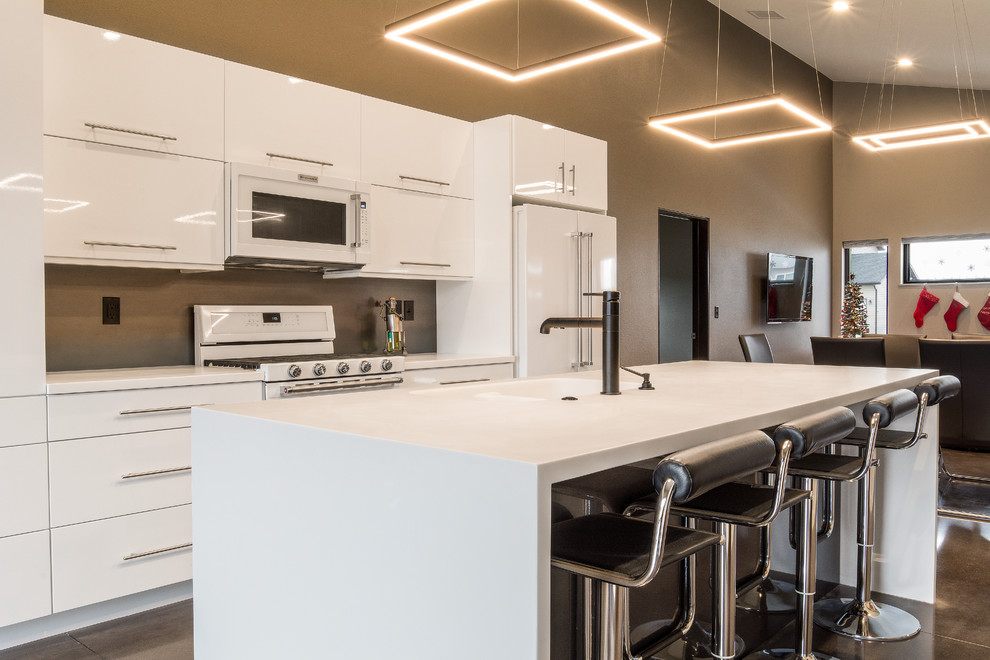 Inspiration for a large modern single-wall concrete floor and brown floor eat-in kitchen remodel in Other with an integrated sink, flat-panel cabinets, white cabinets, solid surface countertops, brown backsplash, white appliances and an island