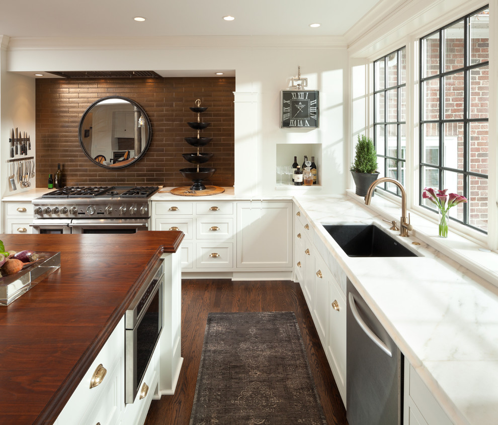 Transitional l-shaped dark wood floor kitchen photo in Minneapolis with an undermount sink, shaker cabinets, white cabinets, brown backsplash and an island