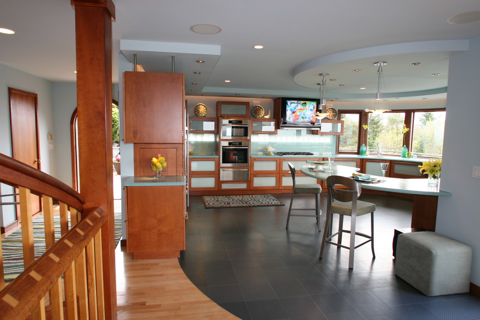 Foto di una grande cucina ad U moderna chiusa con ante di vetro, ante in legno scuro, paraspruzzi verde, paraspruzzi con lastra di vetro e elettrodomestici in acciaio inossidabile