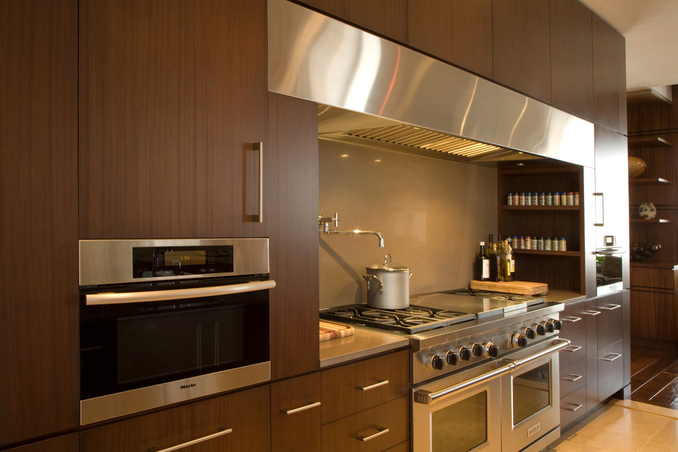 Große Moderne Küche mit hellbraunen Holzschränken, Küchengeräten aus Edelstahl und Travertin in Sonstige
