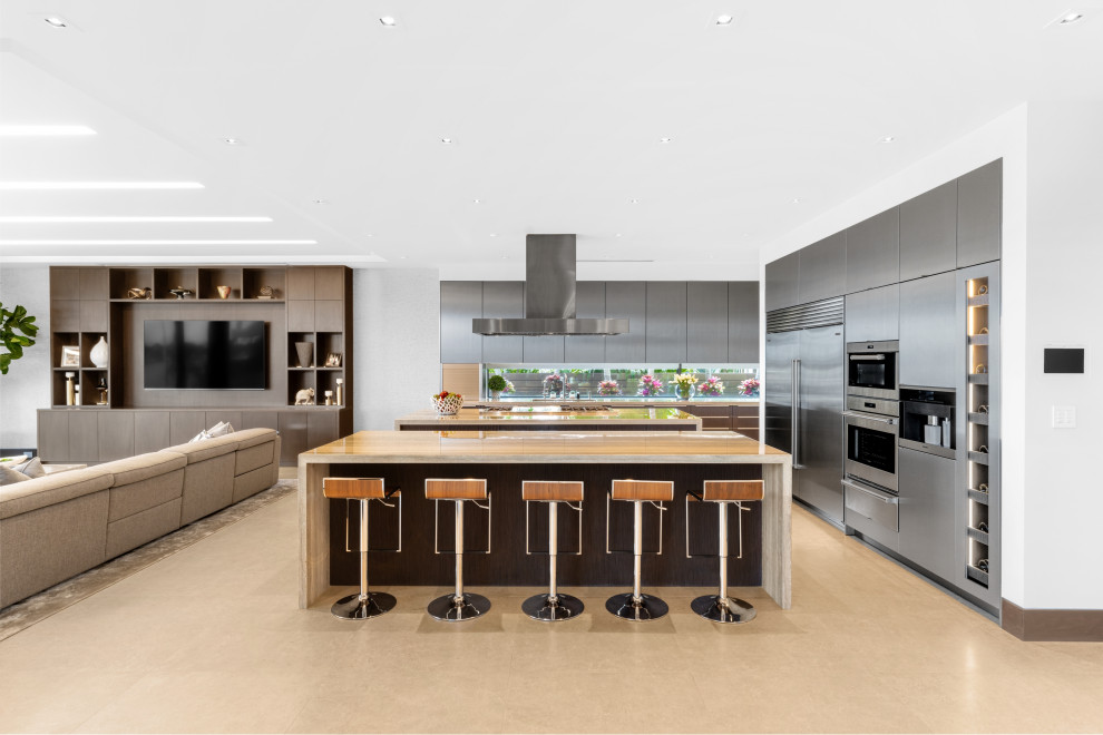 Esempio di una grande cucina design con ante lisce, ante grigie, paraspruzzi a finestra, elettrodomestici in acciaio inossidabile, 2 o più isole, pavimento beige e top beige