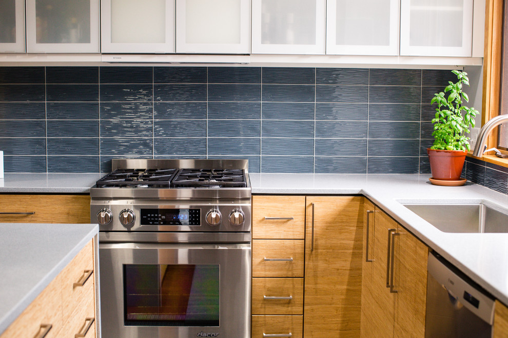 Foto di una cucina moderna di medie dimensioni con lavello a vasca singola, ante lisce, ante in legno chiaro, top in vetro riciclato e elettrodomestici in acciaio inossidabile