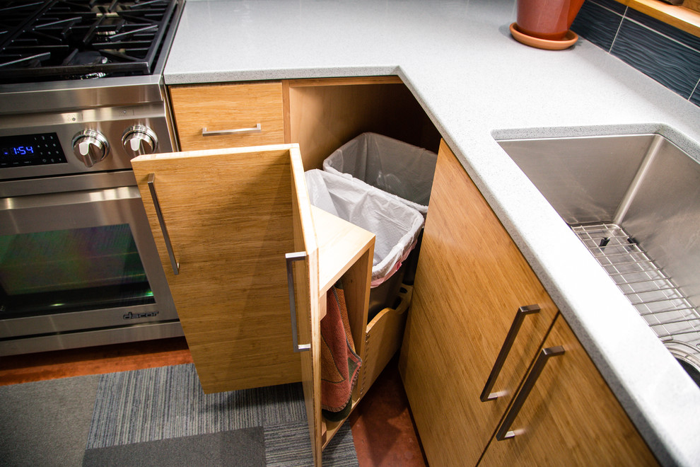 Foto di una cucina minimalista di medie dimensioni con lavello a vasca singola, ante lisce, ante in legno chiaro, top in vetro riciclato e elettrodomestici in acciaio inossidabile