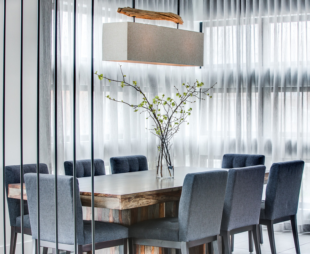 Réalisation d'une grande salle à manger ouverte sur le salon minimaliste avec sol en béton ciré.