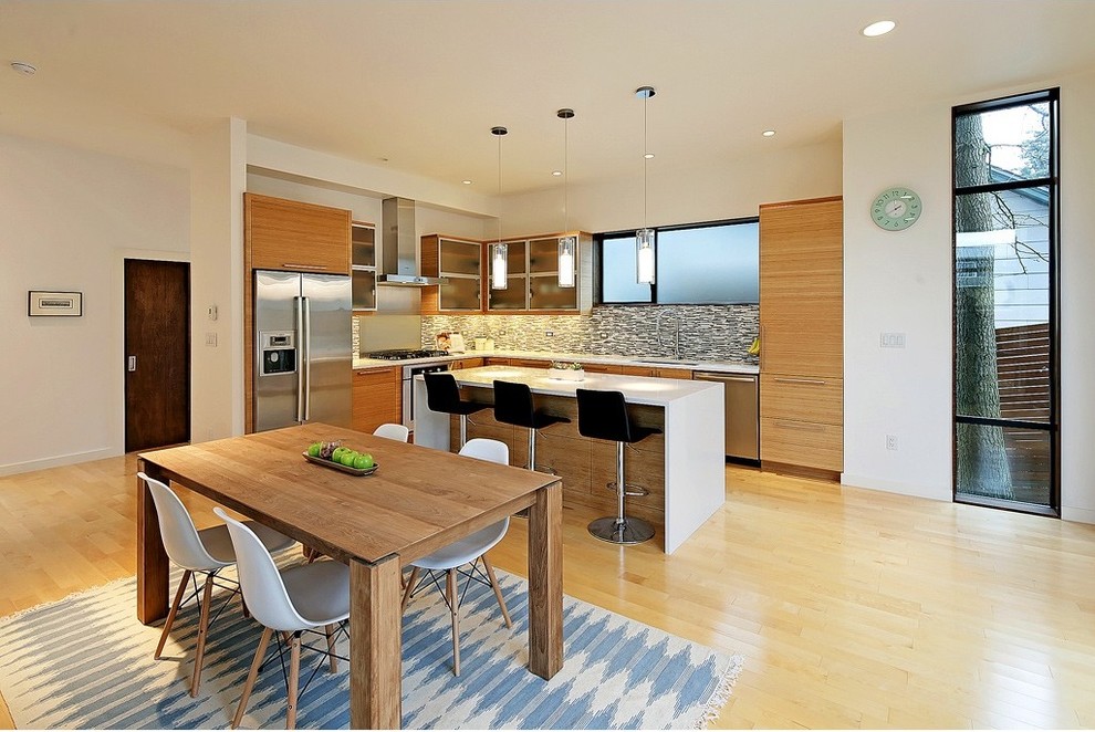 Large minimalist u-shaped bamboo floor eat-in kitchen photo in Dallas with a single-bowl sink, flat-panel cabinets, light wood cabinets, quartz countertops, stainless steel appliances, an island and multicolored backsplash