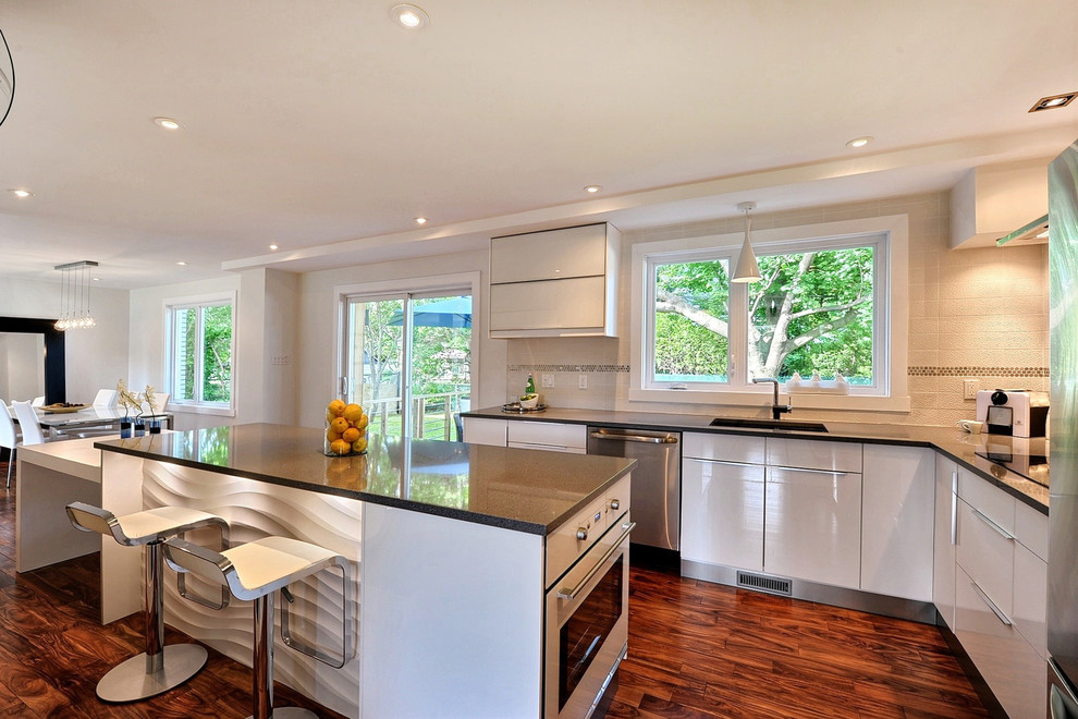 Moderne Küche in L-Form mit flächenbündigen Schrankfronten, weißen Schränken und Küchengeräten aus Edelstahl in Montreal