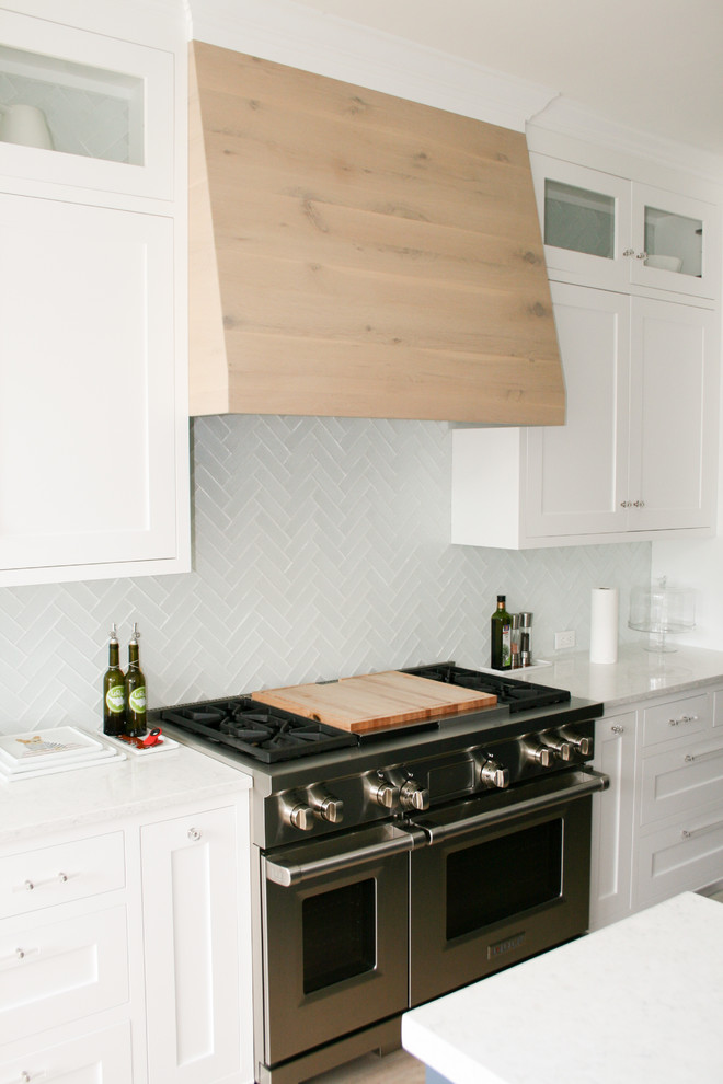 Exempel på ett mellanstort modernt kök, med en dubbel diskho, luckor med infälld panel, vita skåp, granitbänkskiva, blått stänkskydd, stänkskydd i keramik, rostfria vitvaror, mörkt trägolv, en köksö och brunt golv