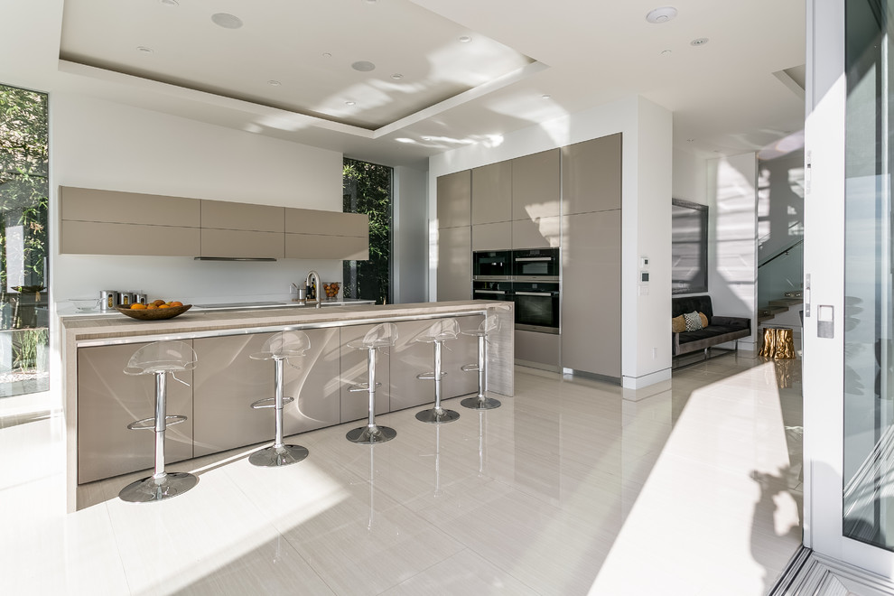 Example of a mid-sized minimalist l-shaped ceramic tile open concept kitchen design in Los Angeles with a double-bowl sink, flat-panel cabinets, beige cabinets, quartz countertops, white backsplash, stainless steel appliances and an island