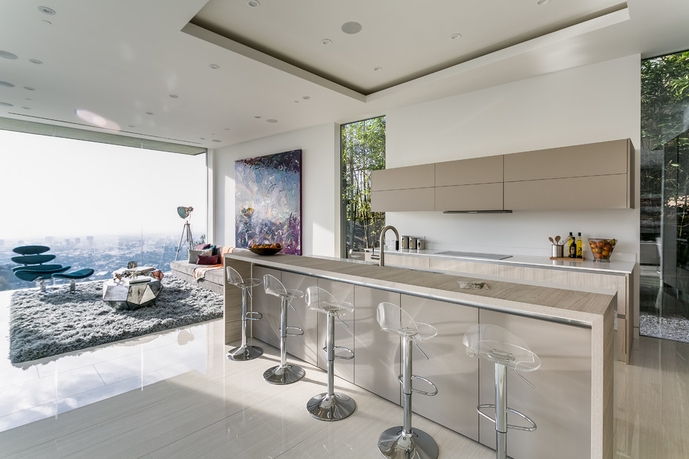 Offene, Zweizeilige Moderne Küche mit flächenbündigen Schrankfronten, beigen Schränken, Küchenrückwand in Weiß und Kücheninsel in Los Angeles