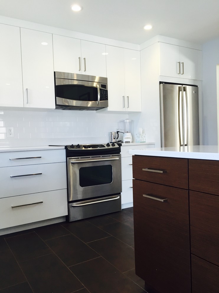 Photo of a contemporary kitchen/diner in Providence with white cabinets, engineered stone countertops, white splashback, metro tiled splashback, stainless steel appliances, porcelain flooring and an island.