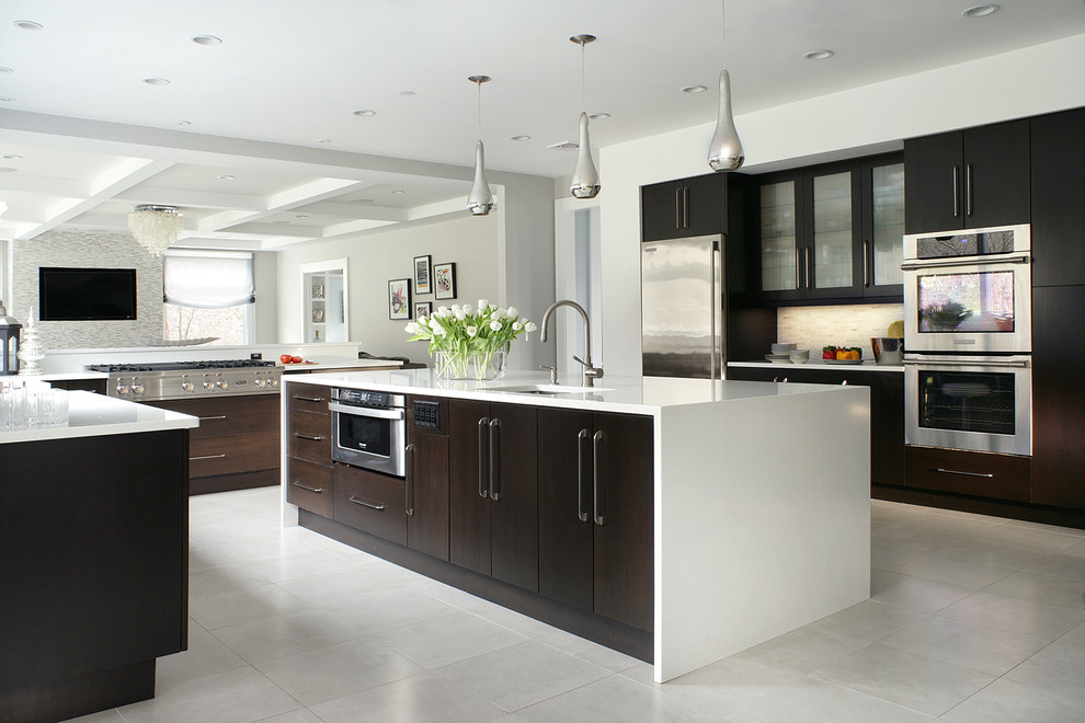 This is an example of a contemporary kitchen in New York with flat-panel cabinets, stainless steel appliances, dark wood cabinets and white floors.