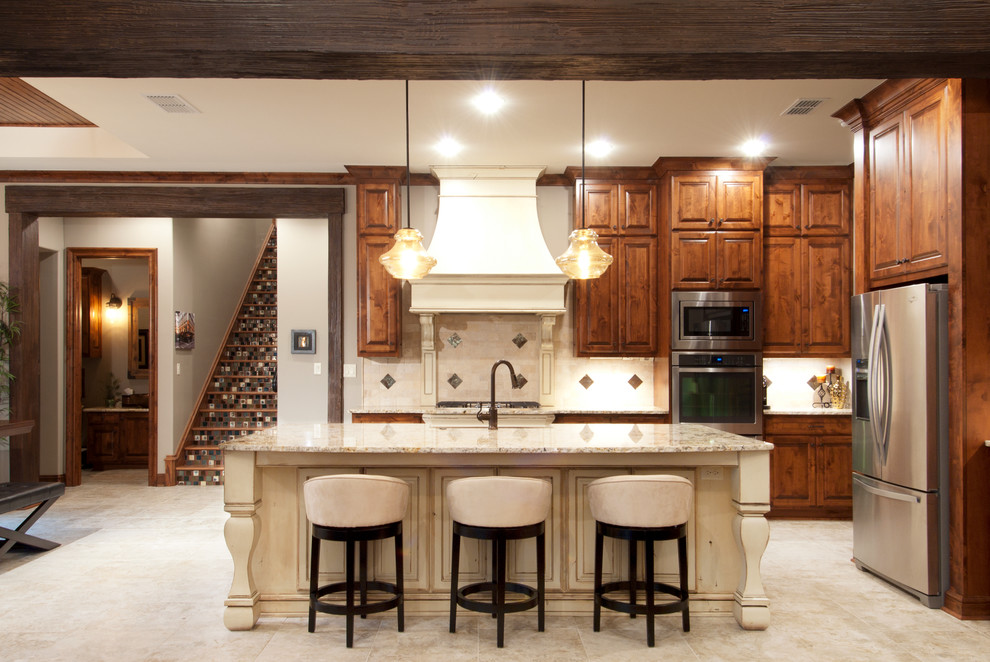 Foto på ett mellanstort industriellt kök, med en rustik diskho, luckor med upphöjd panel, skåp i mellenmörkt trä, granitbänkskiva, beige stänkskydd, stänkskydd i stenkakel, rostfria vitvaror, klinkergolv i porslin och en köksö