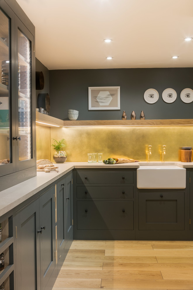 This is an example of a small urban l-shaped enclosed kitchen in Other with a belfast sink, shaker cabinets, grey cabinets, engineered stone countertops, metallic splashback, metal splashback and no island.