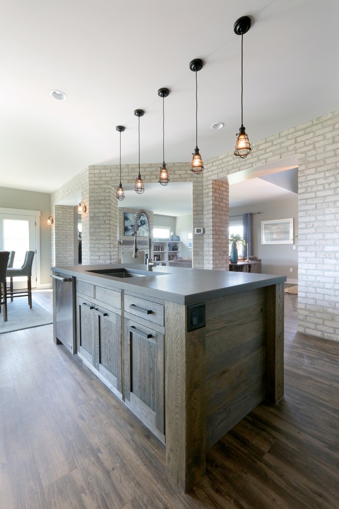 Photo of an urban kitchen in Grand Rapids with a submerged sink, recessed-panel cabinets, white cabinets, concrete worktops, stainless steel appliances, dark hardwood flooring and an island.