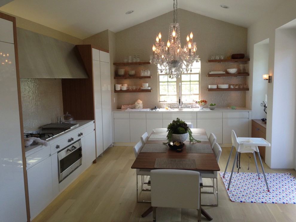 Eat-in kitchen - small modern l-shaped light wood floor eat-in kitchen idea in Orange County with flat-panel cabinets, white cabinets, limestone countertops, ceramic backsplash, stainless steel appliances and no island