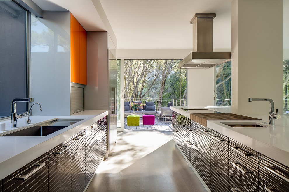Exemple d'une cuisine moderne avec un électroménager en acier inoxydable, des portes de placard oranges et fenêtre au-dessus de l'évier.