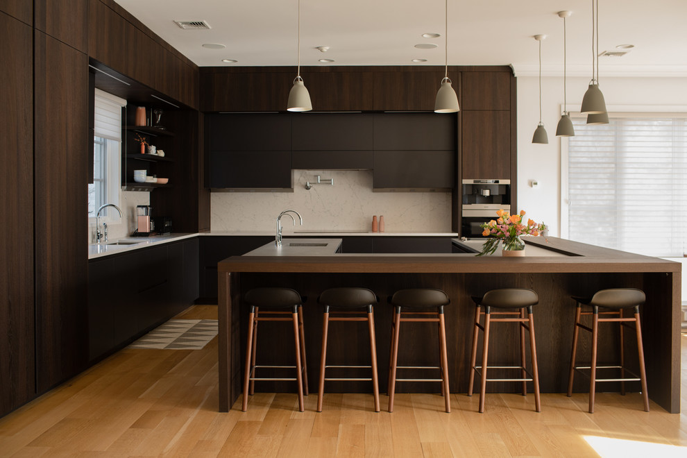 Moderne Küche in U-Form mit flächenbündigen Schrankfronten, Küchenrückwand in Beige, braunem Holzboden, Kücheninsel, braunem Boden, brauner Arbeitsplatte und dunklen Holzschränken in New York