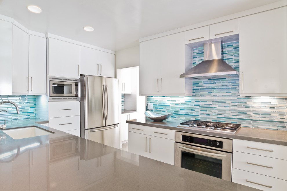 Inspiration for a modern kitchen remodel in Los Angeles with a single-bowl sink, flat-panel cabinets, white cabinets, quartz countertops, blue backsplash, matchstick tile backsplash and stainless steel appliances