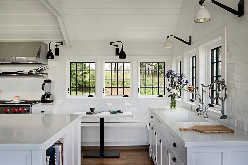 Imagen de cocina campestre con armarios estilo shaker, salpicadero blanco, salpicadero de azulejos tipo metro, suelo de madera oscura y con blanco y negro
