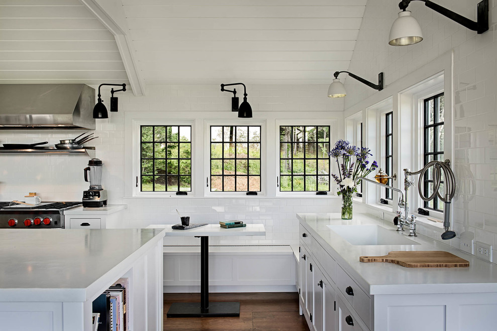 Example of a farmhouse dark wood floor kitchen design in New York with shaker cabinets, white backsplash and subway tile backsplash