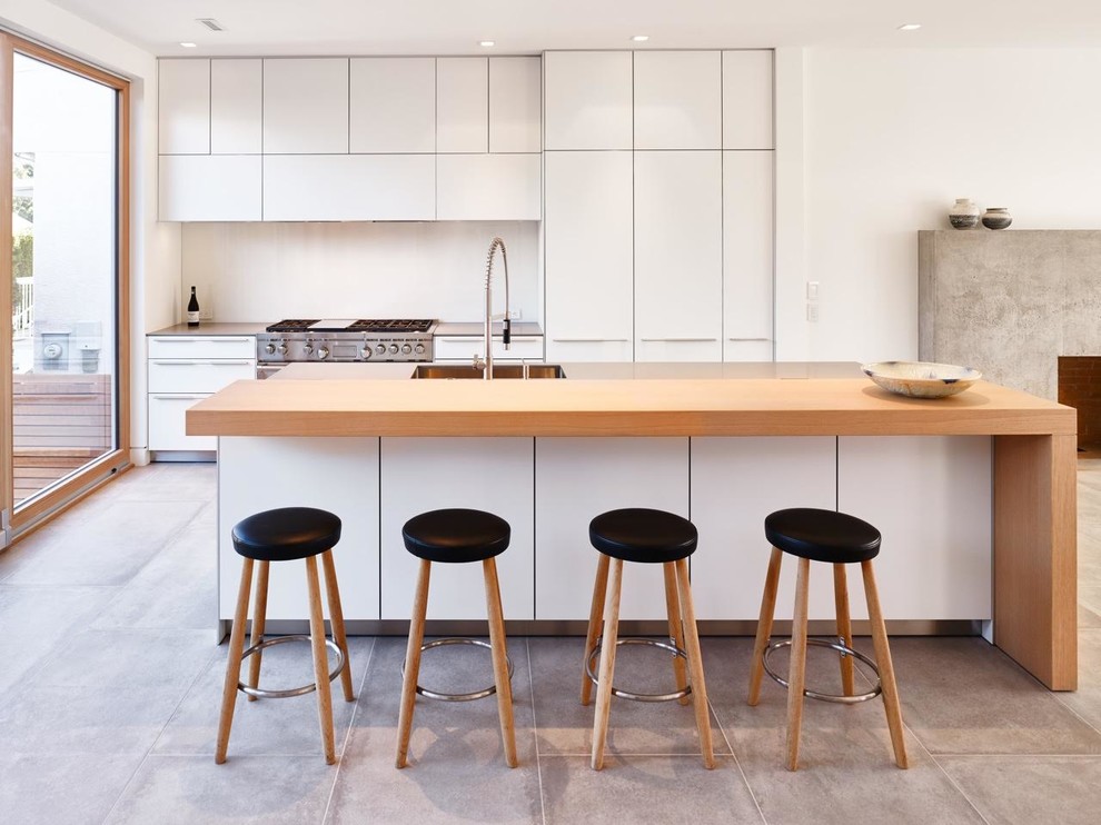 Offene, Zweizeilige Moderne Küche mit flächenbündigen Schrankfronten, weißen Schränken, Arbeitsplatte aus Holz und Kücheninsel in Vancouver