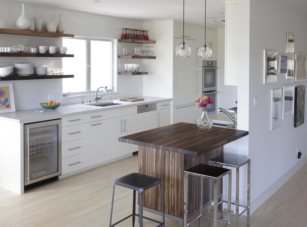 Inspiration for a modern galley kitchen in Birmingham with a single-bowl sink, open cabinets, white cabinets, integrated appliances, engineered stone countertops and white splashback.