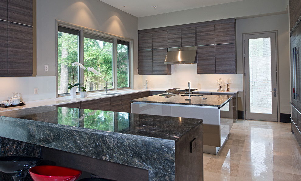 Expansive contemporary u-shaped enclosed kitchen in Houston with a submerged sink, engineered stone countertops, white splashback, glass sheet splashback, integrated appliances, flat-panel cabinets, brown cabinets, marble flooring, an island and beige floors.