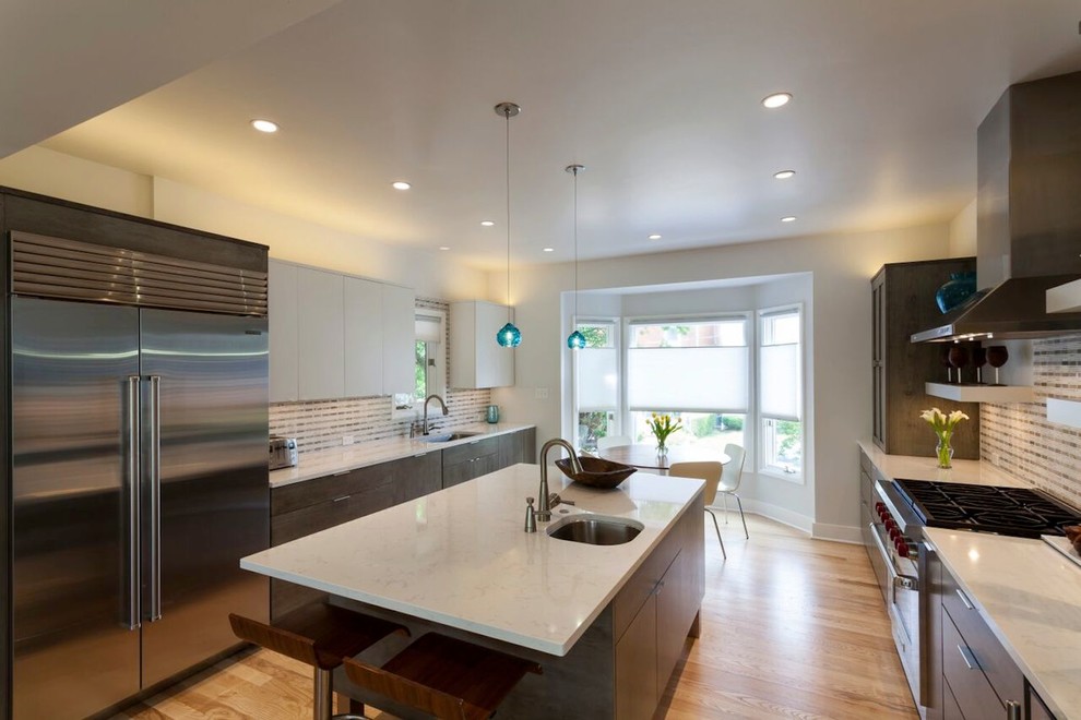 Inspiration for a large modern galley light wood floor open concept kitchen remodel in Philadelphia with a drop-in sink, shaker cabinets, gray cabinets, multicolored backsplash, stainless steel appliances and an island