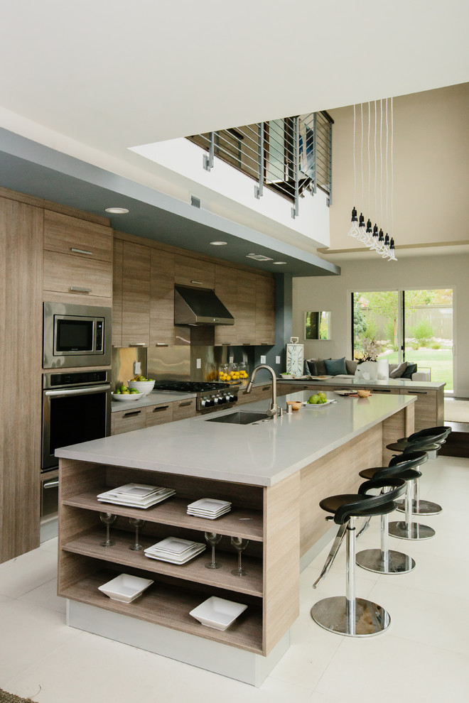 Eat-in kitchen - large contemporary galley ceramic tile and white floor eat-in kitchen idea in Los Angeles with an undermount sink, flat-panel cabinets, light wood cabinets, quartz countertops, metallic backsplash, stainless steel appliances and an island