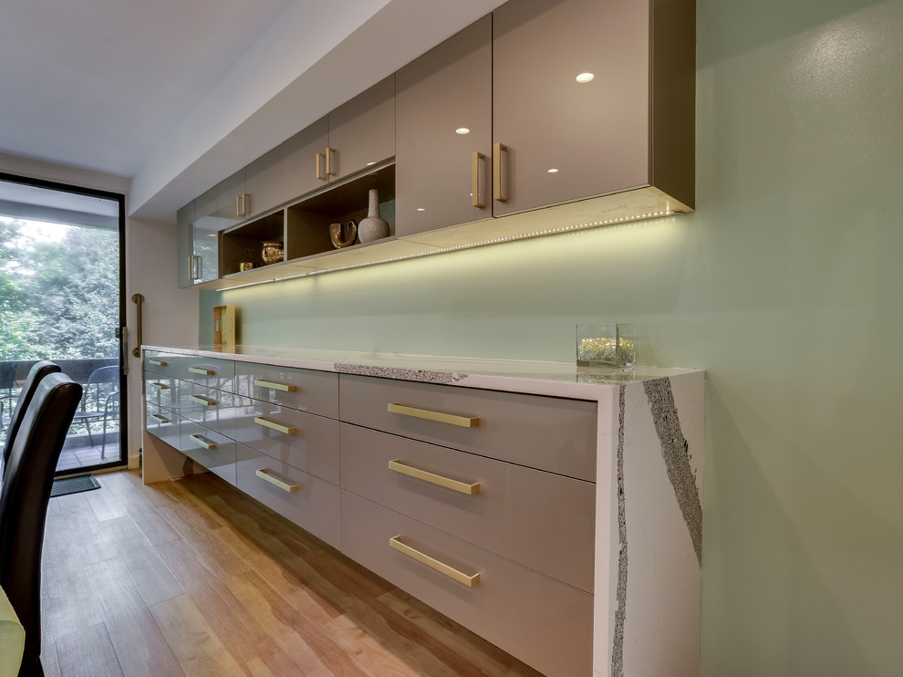Cette image montre une cuisine minimaliste avec un évier encastré, un placard à porte plane, un plan de travail en quartz modifié, une crédence en carreau de verre et un électroménager en acier inoxydable.