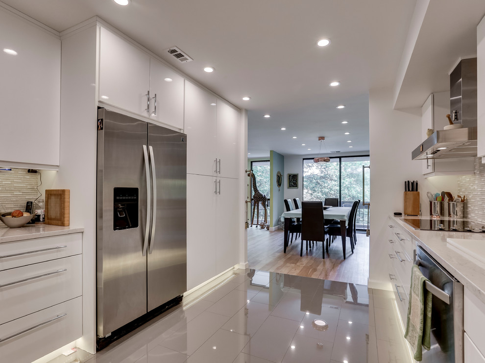 Inspiration for a modern kitchen remodel in DC Metro with an undermount sink, flat-panel cabinets, quartz countertops, glass tile backsplash and stainless steel appliances