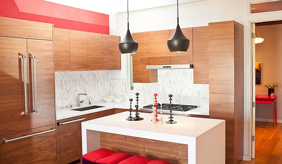 Aménagement d'une cuisine encastrable contemporaine en bois brun avec un placard à porte plane et une crédence en marbre.