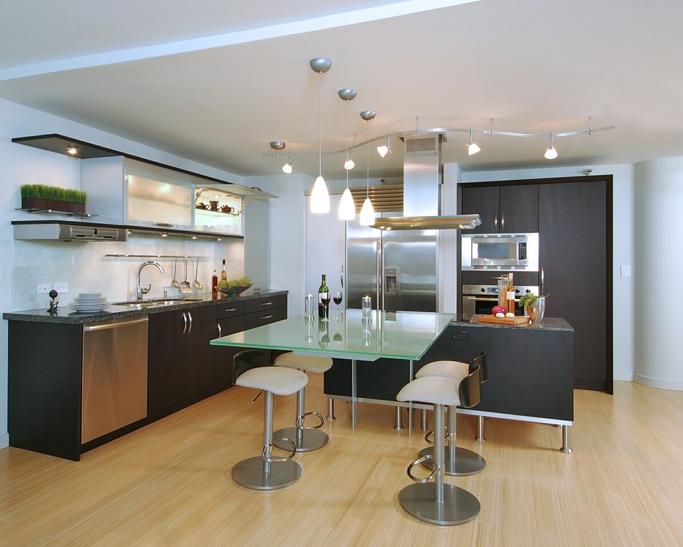 Moderne Küche mit Glasfronten, Küchengeräten aus Edelstahl, Unterbauwaschbecken, dunklen Holzschränken, Glas-Arbeitsplatte und Glasrückwand in Hawaii