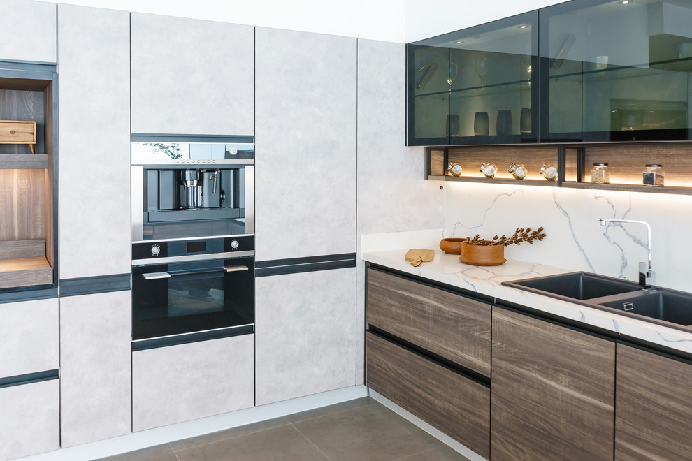 Medium sized modern l-shaped kitchen/diner in Los Angeles with a double-bowl sink, flat-panel cabinets, black cabinets, marble worktops, white splashback, marble splashback, stainless steel appliances, porcelain flooring, multi-coloured floors, white worktops and no island.
